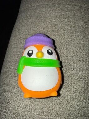 NeeDoh Orange Penguin Squishy Toy with Purple Hat and Green Scarf
